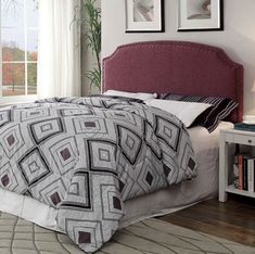 a bed with a red headboard in a bedroom next to a book shelf and window