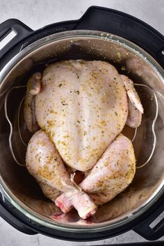 a whole chicken in an instant pot on the stove top, ready to be cooked