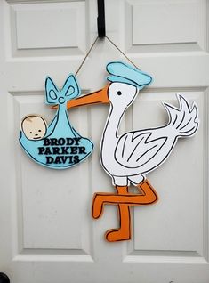 a stork holding a baby in its beak hanging from a door