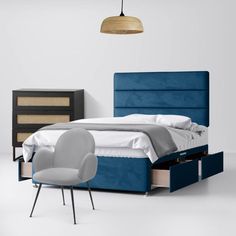 a bed with blue upholstered headboard and foot board next to a night stand