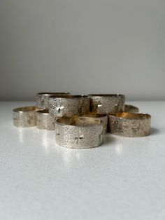 five silver rings sitting on top of a white counter