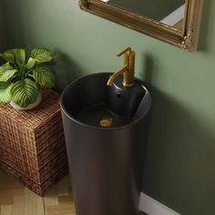 a bathroom sink sitting next to a potted plant