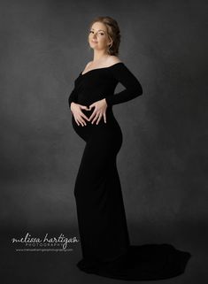 a pregnant woman poses in a black gown