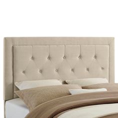 an upholstered headboard on a bed with white sheets and beige linens