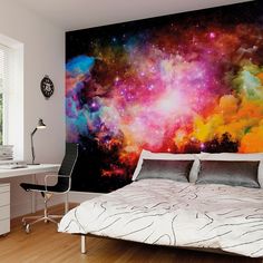 a bed sitting under a colorful wall mural in a bedroom