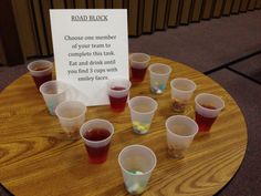 a wooden table topped with cups filled with liquid next to a sign that says obama black