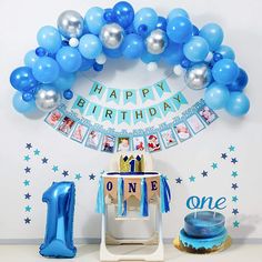 a birthday party with balloons, cake and decorations on the table for one year old