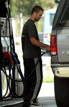 a man filling up his truck with gas