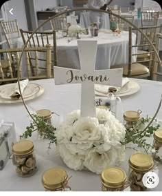 a white table topped with a cross and flowers