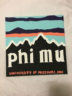 a piece of paper with the word phi mu on it and mountains in the background