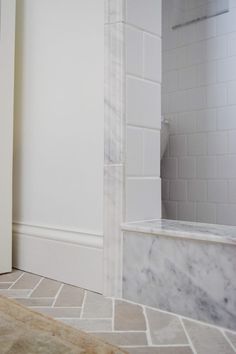 a bathroom with white walls and marble flooring