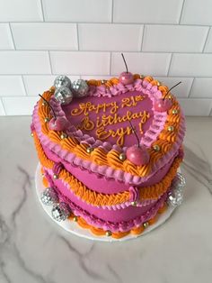 a heart shaped birthday cake sitting on top of a white countertop next to a brick wall