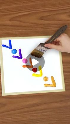 someone is painting letters on a piece of paper