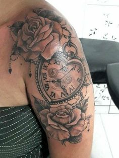 a woman with a clock and roses tattoo on her arm