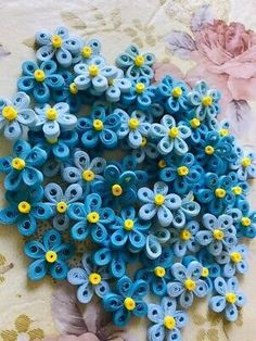 blue and yellow flowers sitting on top of a flowery tablecloth covered in paper