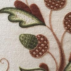 a close up view of some flowers on a piece of white fabric with brown and green accents