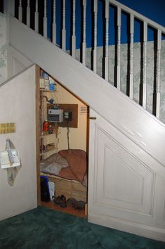 an open door leading to a small bed in a room with green carpeted flooring