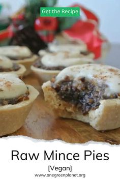 raw mince pies on a wooden cutting board with christmas decorations in the background