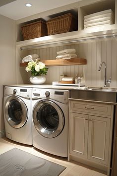 a washer and dryer in a small room with white towels on the shelves