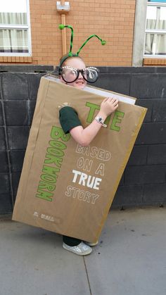 a young boy dressed in costume holding a cardboard sign