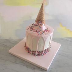 a birthday cake with sprinkles and an ice cream cone on the top