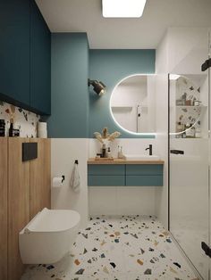 a bathroom with blue and white walls, flooring and a round mirror on the wall