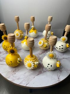 some yellow and white ceramic figurines on a table with wooden dows in the shape of flowers