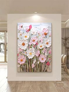 a painting on the wall in a room with wood flooring and white walls, pink flowers