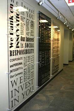 an office hallway decorated with black and white typogramic art on the wall