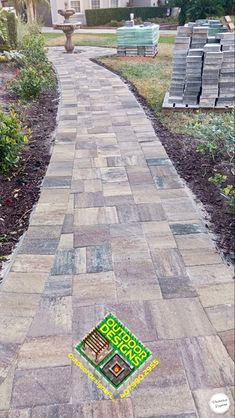 a brick walkway with a patch of grass in the middle and an empty box on the side