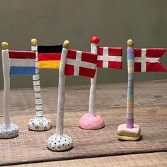 three wooden poles with flags on them sitting on a table