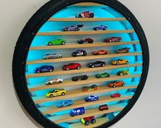 there is a clock that has cars on the shelf in front of it with lights