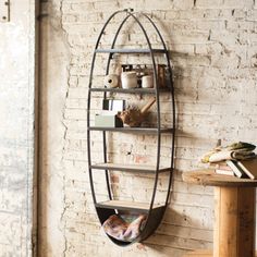 a round metal shelf on the wall next to a table