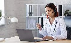 a woman sitting at a desk in front of a laptop computer with headphones on