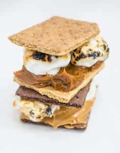 a stack of crackers with ice cream and peanut butter on top, sitting next to each other