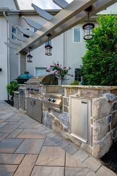 an outdoor kitchen with grill and seating area