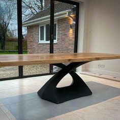 a wooden table sitting in the middle of a room next to a sliding glass door