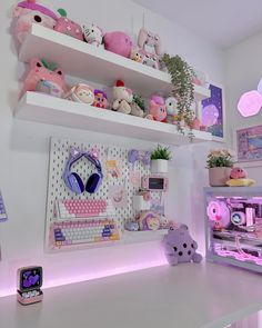 there are many stuffed animals and toys on the shelves above the computer desk in this room