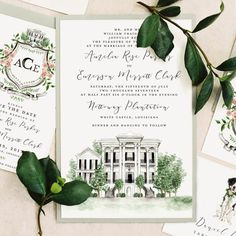 the wedding stationery is decorated with greenery