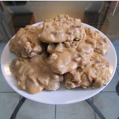 a white plate topped with cookies covered in caramel glaze on top of a tile floor