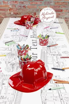 a table topped with red hats and pencils