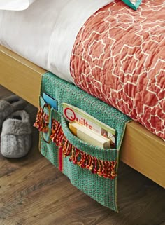 a close up of a bed with a bag on the bottom and shoes next to it