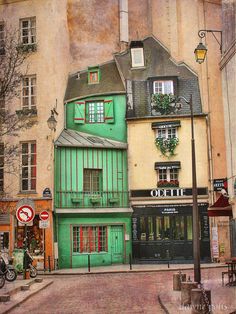 an old building with green shutters and windows