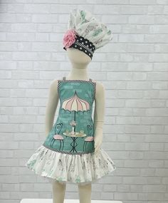 a mannequin wearing a dress and hat with an umbrella on it's head