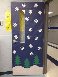 a door decorated with snowflakes and pine trees in a hallway at the school