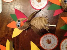 a wooden table topped with paper turkeys and cupcake toppers