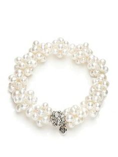 a white bracelet with pearls and a silver beaded charm on the clasp is shown