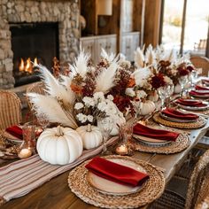 the table is set with white pumpkins and red napkins