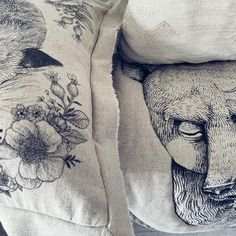 two pillows with designs on them sitting next to each other