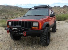 a red jeep is parked in the desert